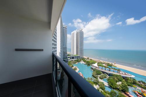 a balcony with a view of the beach and buildings at Dusit Thani Shuangyue Bay Resort Huizhou in Huidong