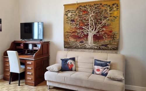 a living room with a couch and a desk with a tv at Delia in Sanremo