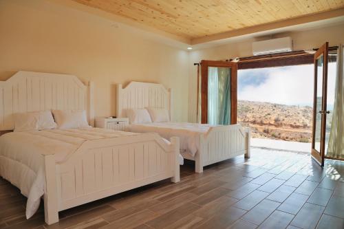 um quarto com 2 camas e uma grande janela em Maple Resort 