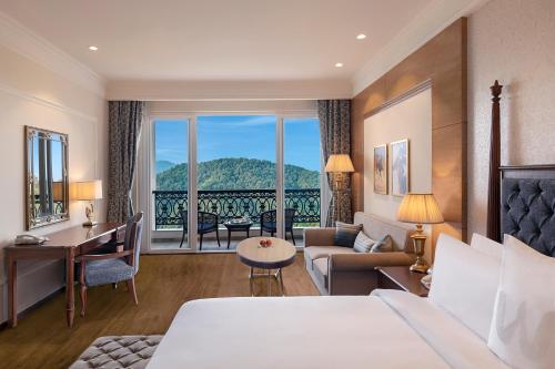 a hotel room with a bed and a living room at Welcomhotel by ITC Hotels, Tavleen, Chail in Chail