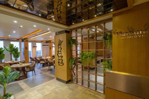 a restaurant with tables and chairs in a building at Sarovar Portico Morbi in Morbi