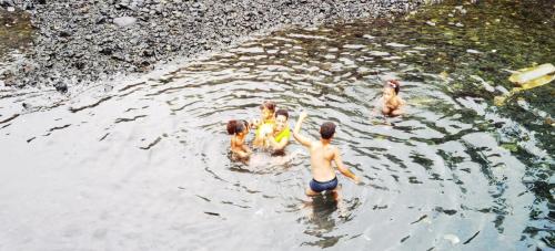 a group of people swimming in a body of water at Ciza e Rose in Portela