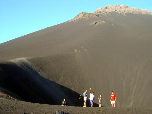 a group of people standing on a beach in front of a mountain at Ciza e Rose in Portela