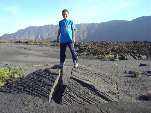 a young boy standing on top of a rock at Ciza e Rose in Portela
