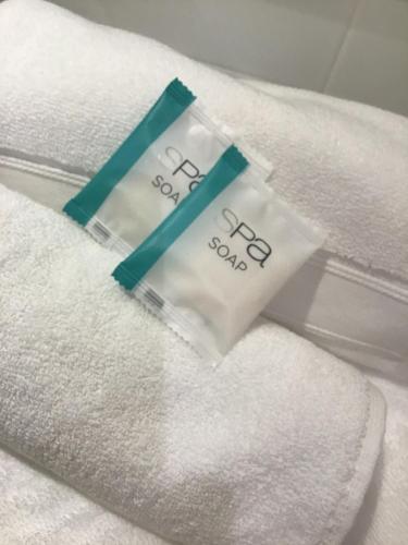 a pair of towels on top of white towels at West End Apartments in Fremantle