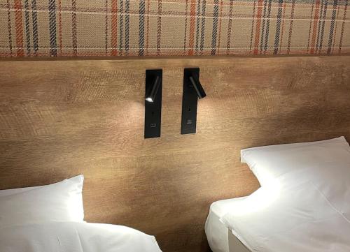 een slaapkamer met 2 bedden en een muur met 2 luidsprekers bij hotel the textile in Gifu