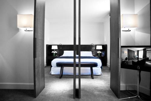 a bedroom with a bed and a mirror at Hotel Montalembert in Paris