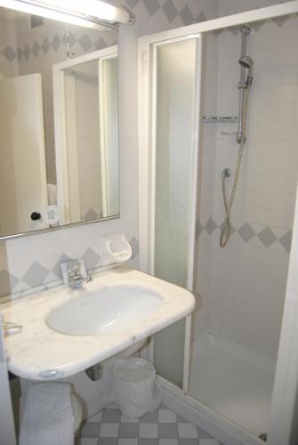 a bathroom with a sink and a shower at Hotel Carlton in Riccione
