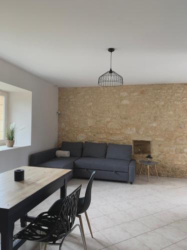 un salon avec un canapé bleu et une table dans l'établissement Maison chaleureuse à la campagne, à Payrignac