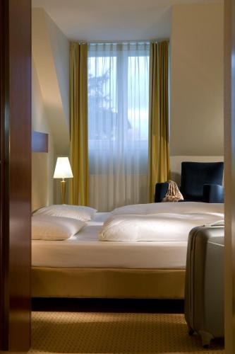 a hotel room with two beds and a window at Novotel Hildesheim in Hildesheim