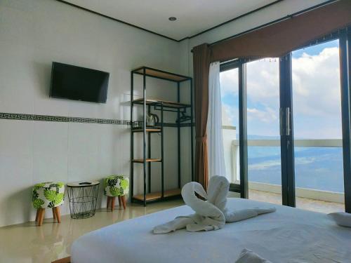 a bedroom with a bed and a large window at Batur view Homestay - Loft in Kintamani