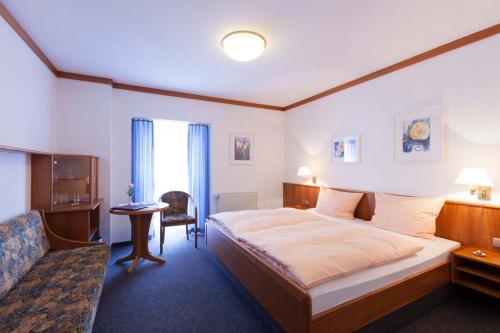 Habitación de hotel con cama y sofá en Hotel Apart, en Reichenbach an der Fils