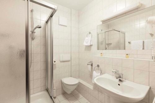 ein Bad mit einem WC, einem Waschbecken und einer Dusche in der Unterkunft Hotel Apart in Reichenbach an der Fils