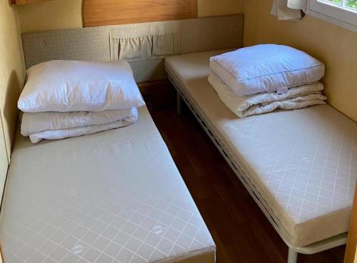 two beds with pillows on them in a small room at Breitner Chalet op de Schatberg in Sevenum