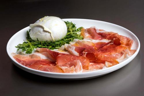 a white plate of food with meat and ice cream at Hotel Stein Collection in Timişoara