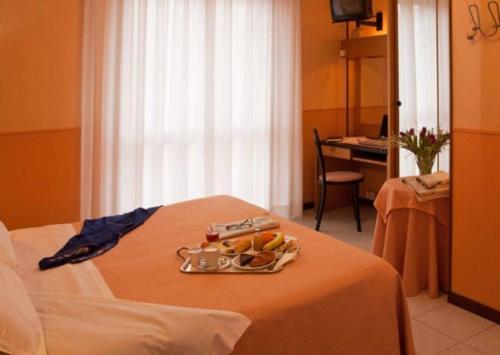una camera d'albergo con un vassoio di frutta su un letto di Giardino Hotel a Milano