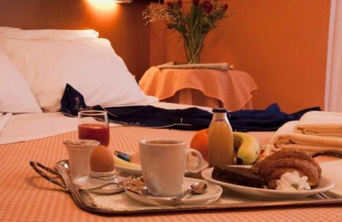 a breakfast tray with food and drinks on a table at Giardino Hotel in Milan