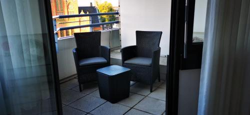 two chairs and a table on a balcony at Stylisches kleines Studio -Zentral gelegen in Leverkusen Wiesdorf - Friedrich Ebert Platz 5a , 4te Etage mit Balkon--Kaution Pflicht-- in Leverkusen