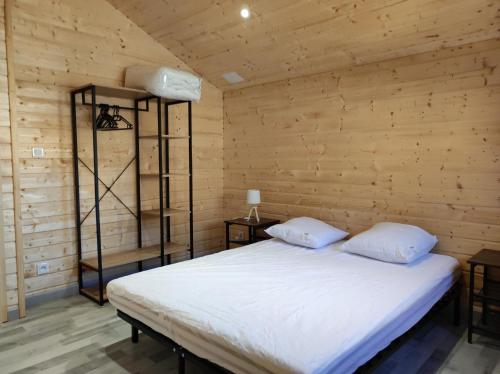 une chambre avec un lit dans un mur en bois dans l'établissement Chalet 6 personnes à la campagne, à Singly