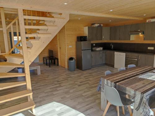 - une cuisine et une salle à manger avec un escalier en bois dans une cabine dans l'établissement Chalet 6 personnes à la campagne, à Singly