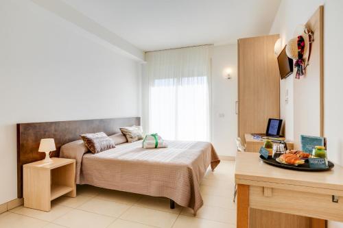 een kleine slaapkamer met een bed en een bureau bij Wally Residence in Rimini