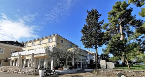 a building with tables and chairs in front of it at RIO B&B, 5 stars SUPERIOR room, near the sea and park in Novigrad Istria