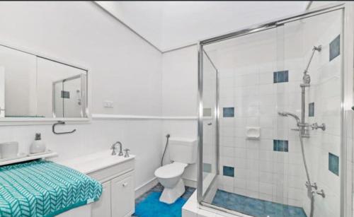 a white bathroom with a shower and a toilet at Island Villas Accommodation Unit 4-108 Arcadia Drive Shoalwater in Safety Bay