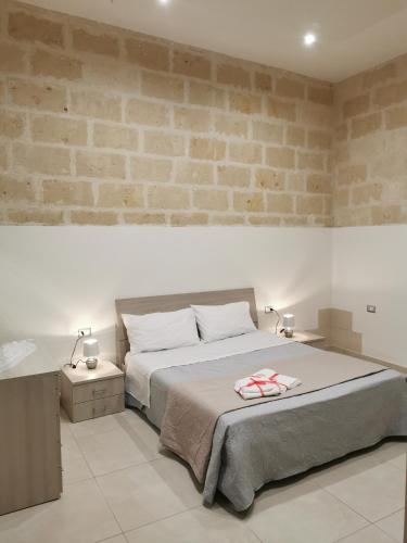 una camera con letto e muro di mattoni di Piccola Stella a Matera