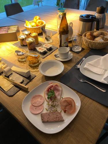 a wooden table with a plate of food on it at BEUKENHOUSE in Drogenbos