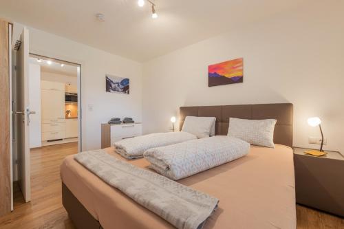 2 łóżka w sypialni z białymi ścianami i drewnianą podłogą w obiekcie Apartment Stubai w Neustift im Stubaital