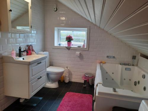 a bathroom with a sink toilet and a window at Gårdslägenhet nära Göteborg 