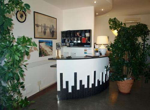 - un bar dans une salle ornée de plantes en pot dans l'établissement Hotel La Conchiglia, à La Maddalena
