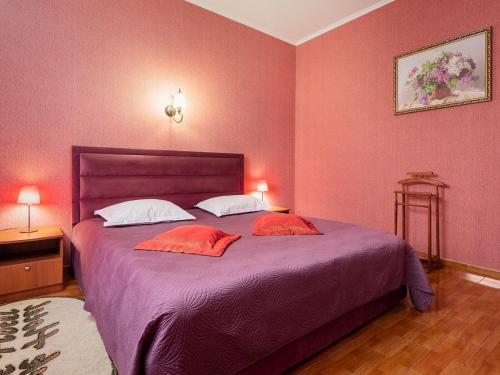 a bedroom with a large bed with pink walls at Park Hotel in Khmelʼnytsʼkyy