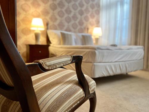 a chair in a hotel room with two beds at OPERA16 Guestrooms in Budapest