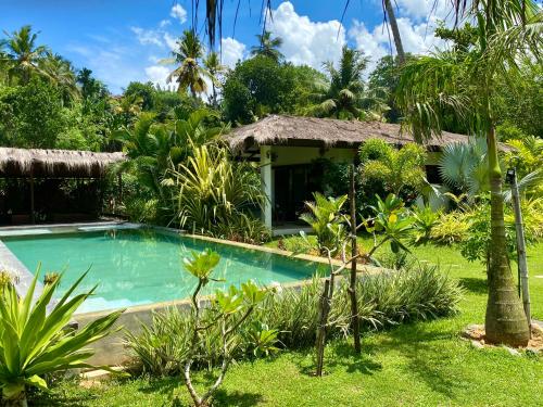 a villa with a swimming pool in a garden at Vanina Villas in Matara