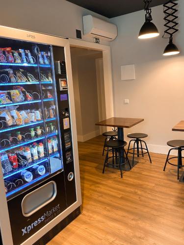a vending machine in a room with tables and tables at Villa Graça -Hostels and Apartments in Santarém