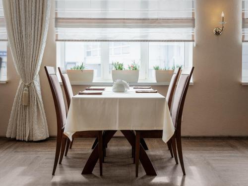a dining room table with chairs and a white table cloth at Park Hotel in Khmelʼnytsʼkyy