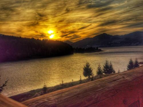a painting of a sunset over a body of water at Chalet du Lac in Colibiţa