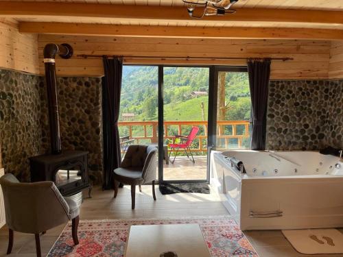 a room with a tub and a table and chairs at Ekakta bungalov in Çamlıhemşin