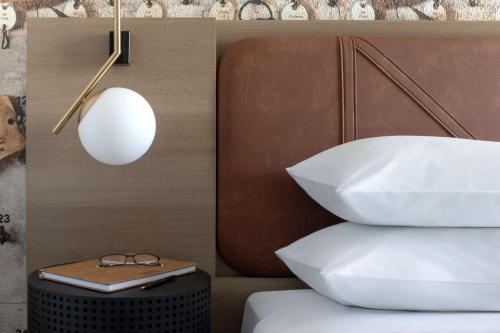 a bed with white pillows and a table with a lamp at Hyatt Centric Beale Street Memphis in Memphis
