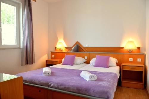 Habitación de hotel con 2 camas y toallas. en Apartments Gera, en Dubrovnik
