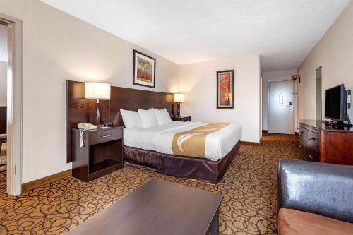 a hotel room with a bed and a television at Quality Inn & Suites Escanaba North in Escanaba