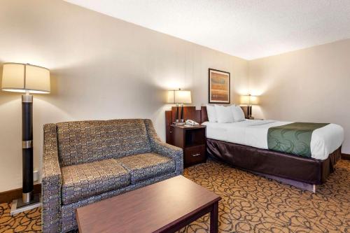 a hotel room with a bed and a couch at Quality Inn & Suites Escanaba North in Escanaba
