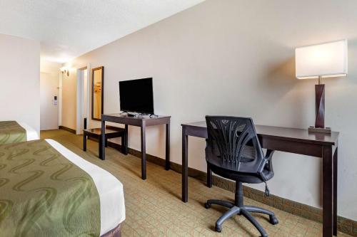 a hotel room with a bed and a desk and a computer at Quality Inn & Suites Escanaba North in Escanaba