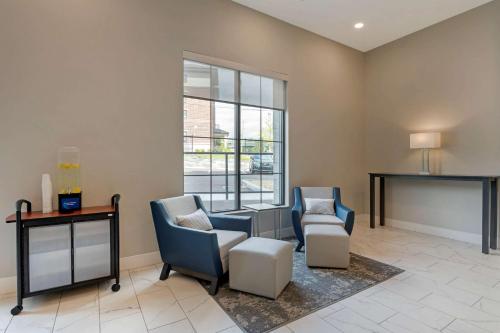a living room filled with furniture and a large window at MainStay Suites Cincinnati University - Uptown in Cincinnati