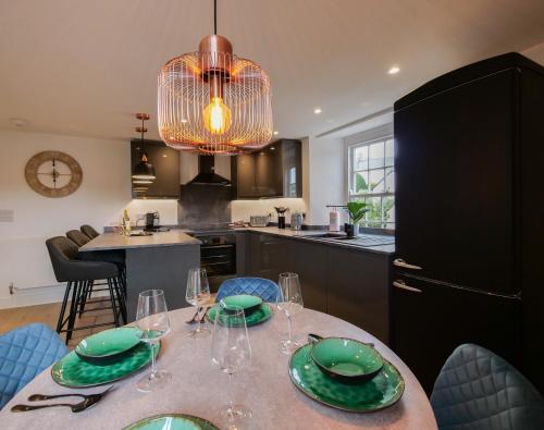 a kitchen with a table with green plates and wine glasses at Kingsbridge Penthouse in Kingsbridge
