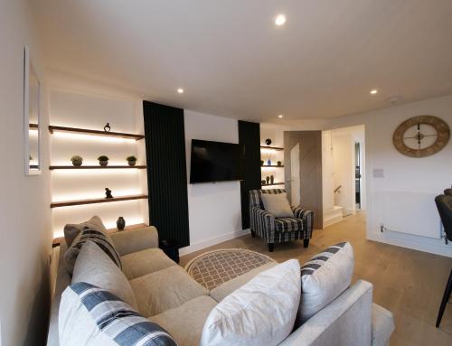 a living room with a couch and a tv at Kingsbridge Penthouse in Kingsbridge