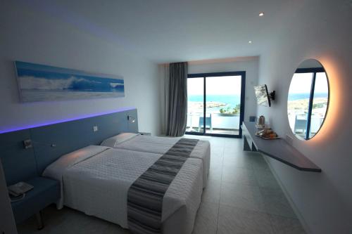 a bedroom with a large bed and a large window at Anonymous Beach Hotel (Adults 16+) in Ayia Napa