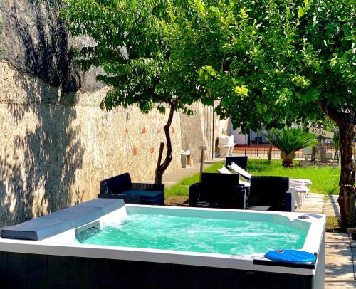una bañera de hidromasaje en un patio con sillas y árboles en Eden Holiday, en Minori