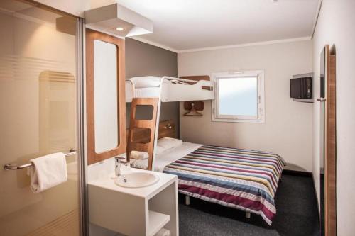 Cette petite chambre comprend des lits superposés et un lavabo. dans l'établissement SUN1 ALBERTON, à Johannesbourg